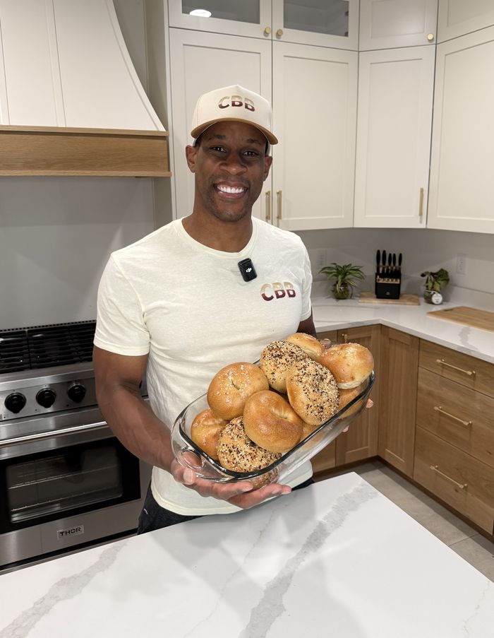 Wuta, founder of City Boy Bagels, holding a fresh batch of hand-rolled bagels